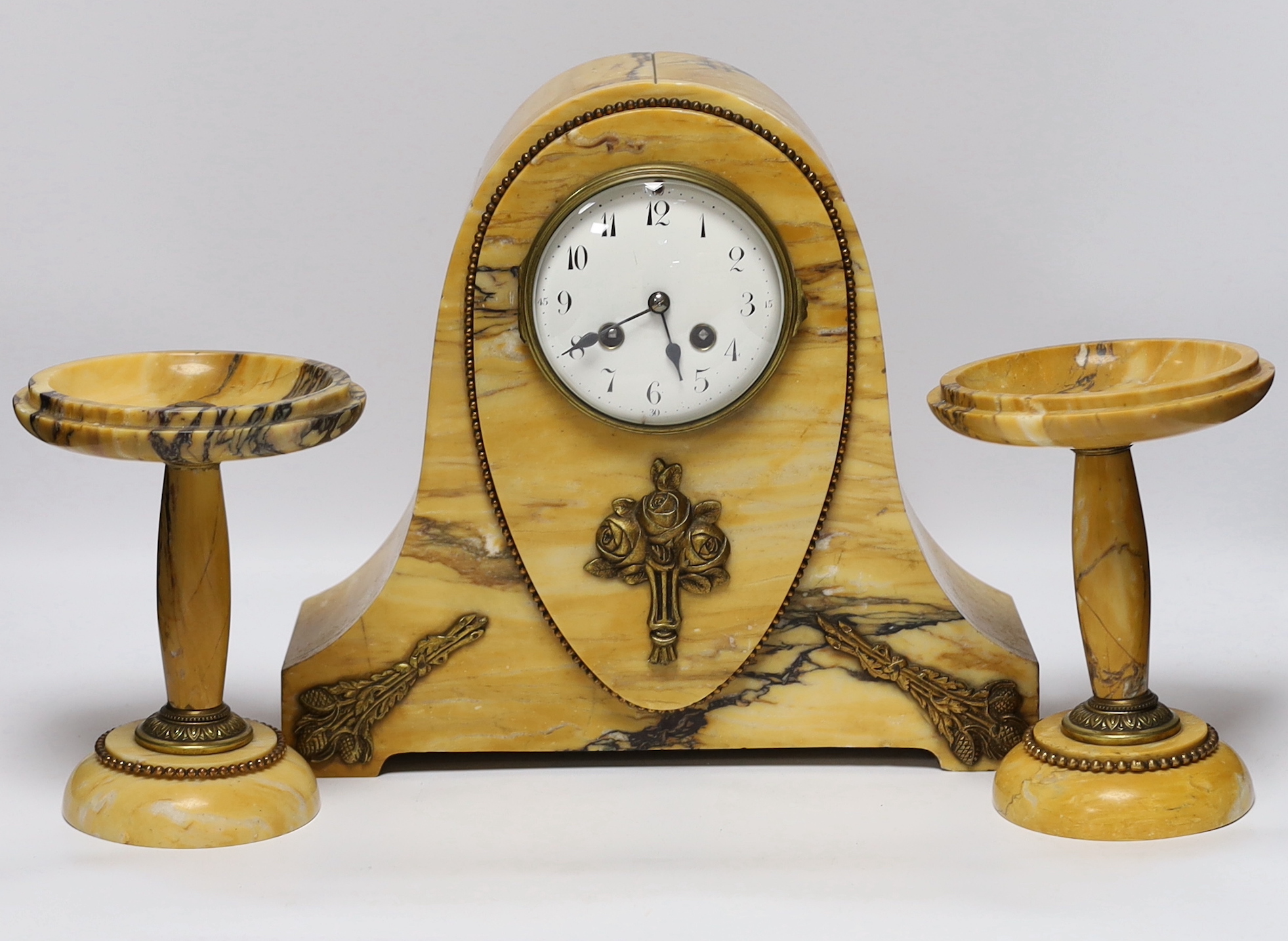 An early 20th century French Sienna marble clock garniture, 30cm
